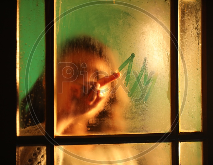 Indian Young Woman Or Girl Faded Behind Glass And Writing With Finger On Glass