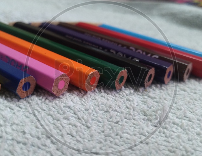 Colour Pencils On a White Cloth Surface  Closeup