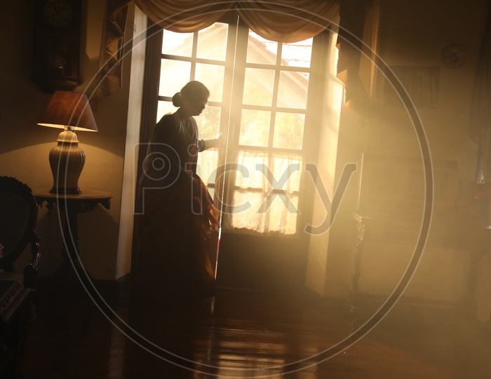 Silhouette Of a Woman Standing at a Window