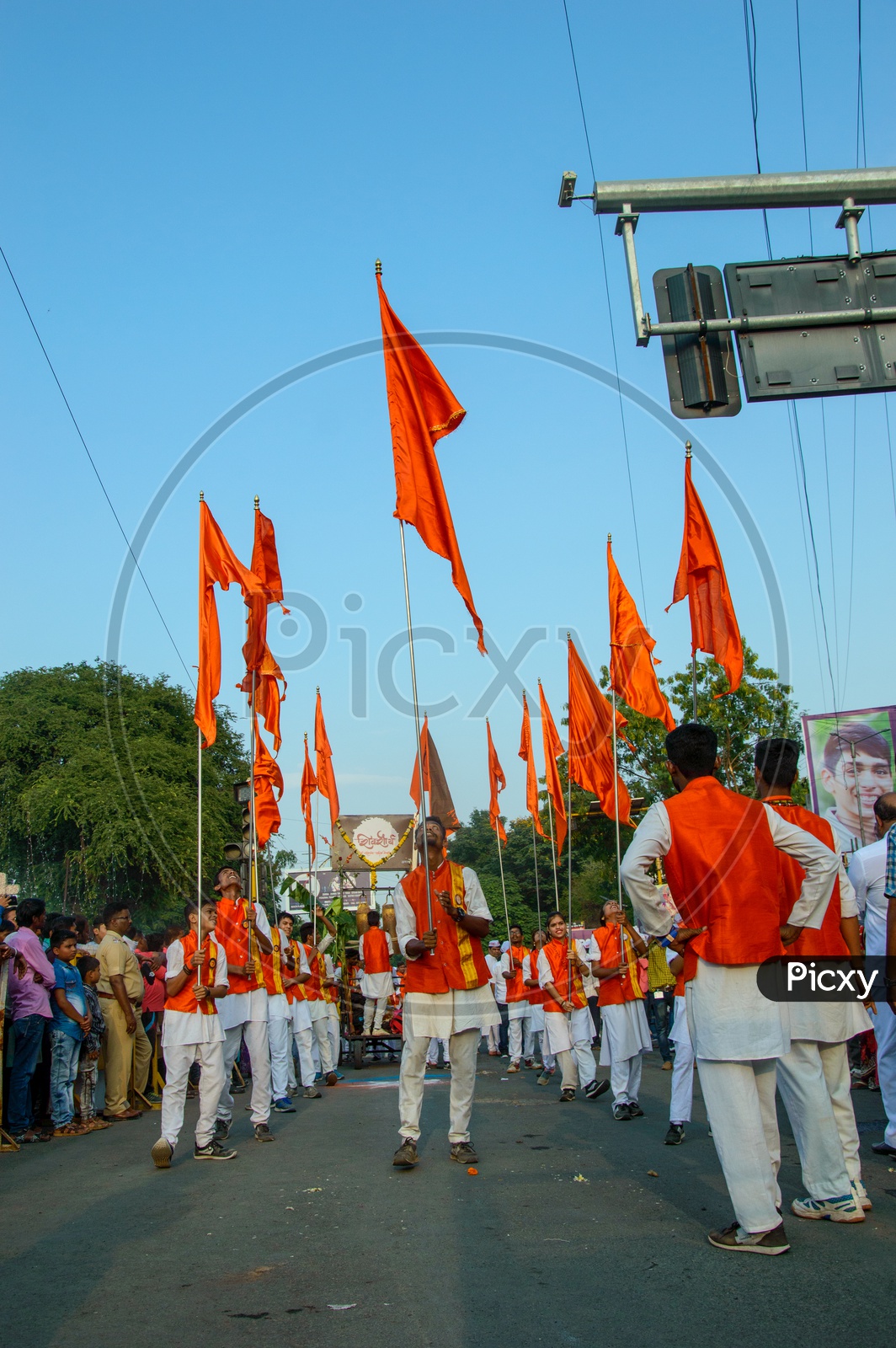 A Group of Man Performing And Dancing On the Streets Holding Saffron Flags During Lord Hanuman Procession