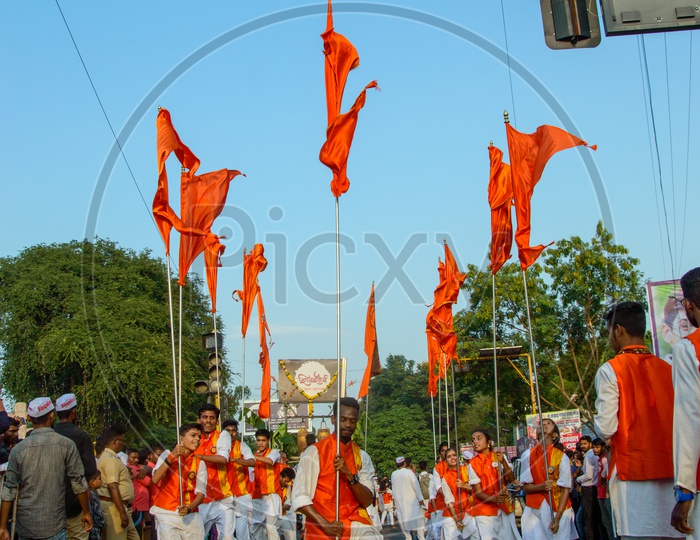 A Group of Man Performing And Dancing On the Streets Holding Saffron Flags During Lord Hanuman Procession