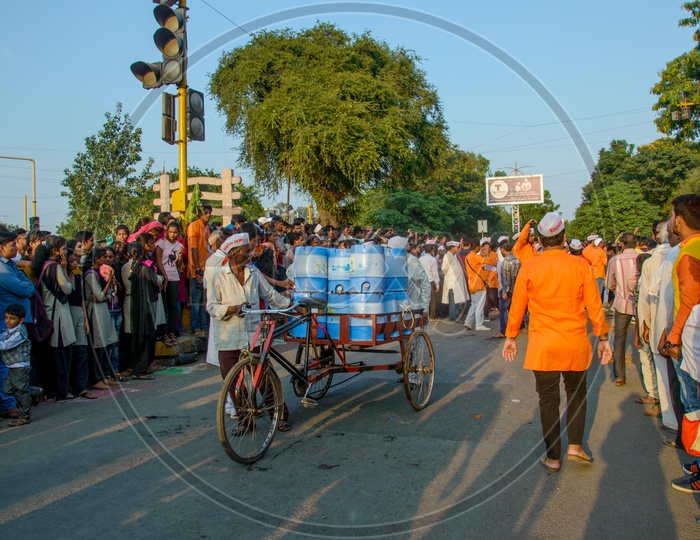 A Rickshaw Puller Carrying Water Bubbles Or Water Cans in Rickshaw