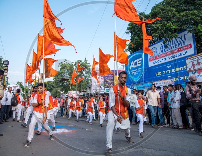 A Group of Man Performing And Dancing On the Streets Holding Saffron Flags During Lord Ganesh  Immersion on Ganesh Chaturdhi Festival