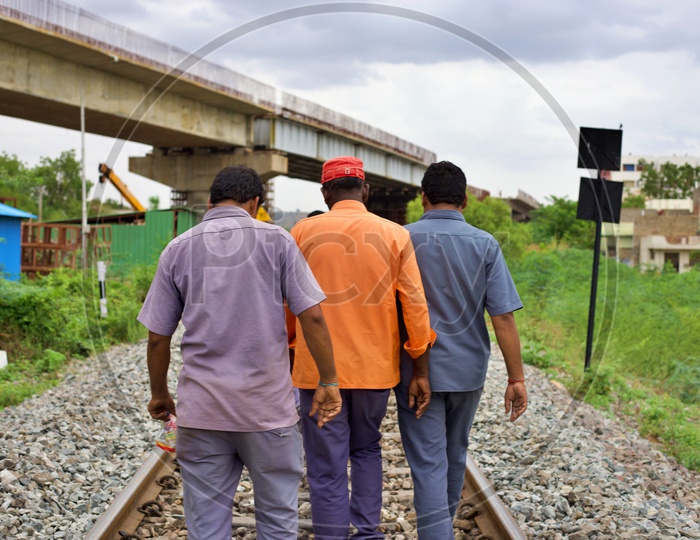 Railway workers walking on tracks.