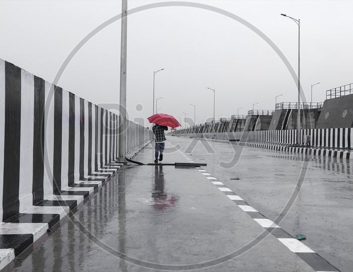 A boy walking on kaleshwaram project dam, while it was drizzling.