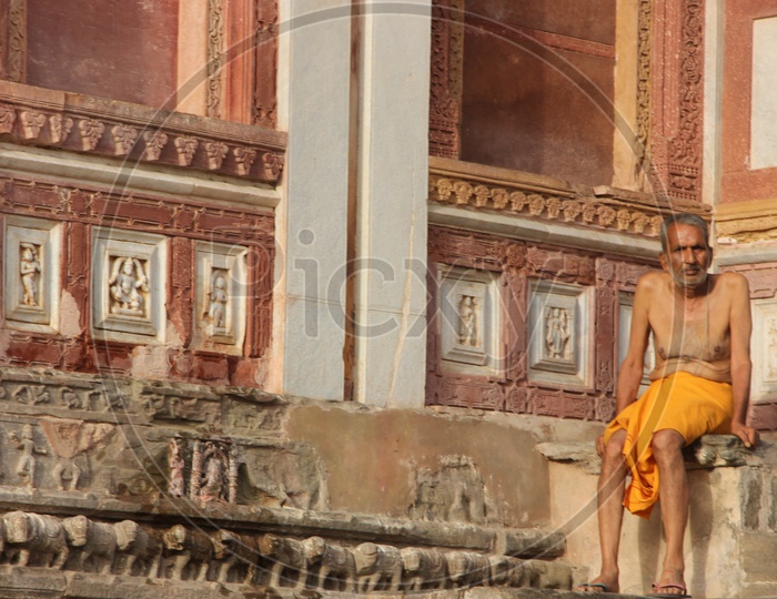Indian Priest Sitting On A Temple Stairs
