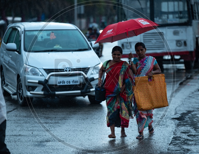 Indian Woman In Rain Under Umbrella On City Roads