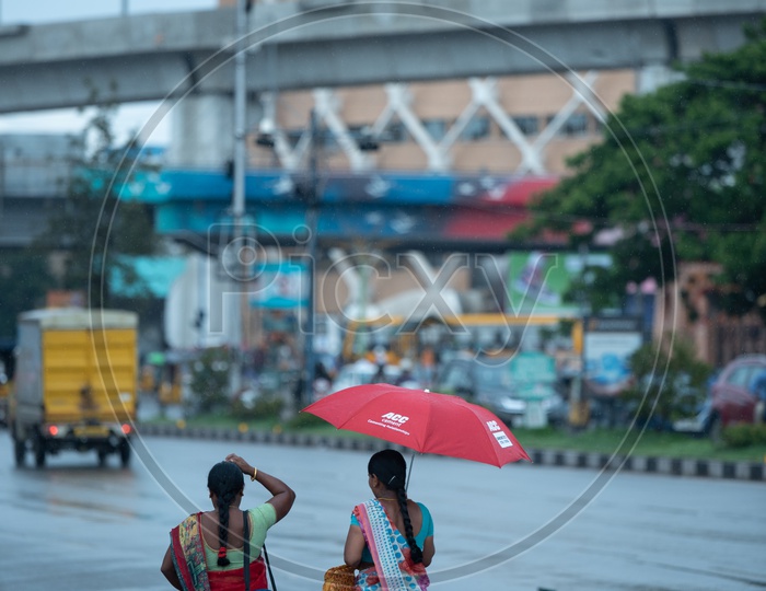Indian Woman In Rain Under Umbrella On Hi-tech City Roads  Near Cyber Towers
