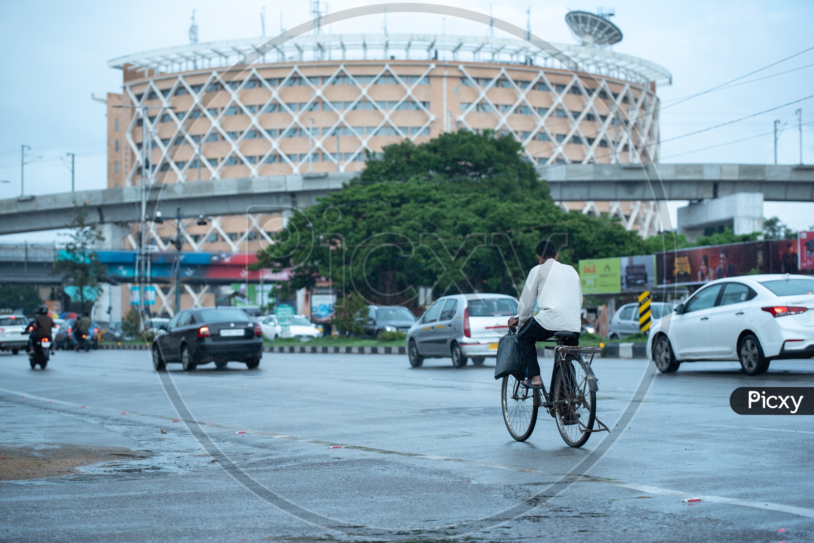 A Man Riding a Bicycle on The Roads of Hi-tech City Near Cyber Towers
