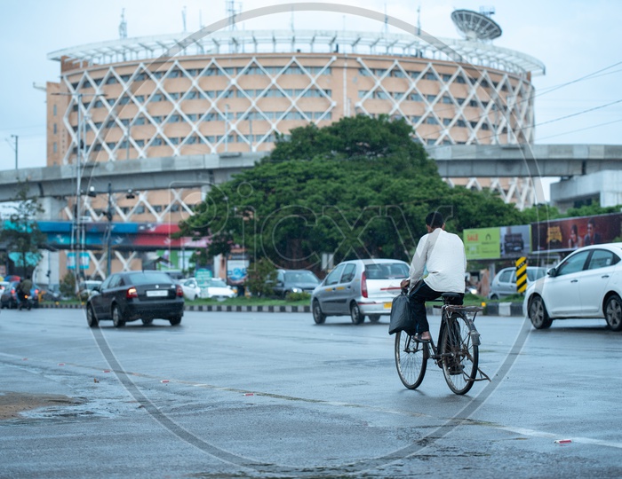 A Man Riding a Bicycle on The Roads of Hi-tech City Near Cyber Towers
