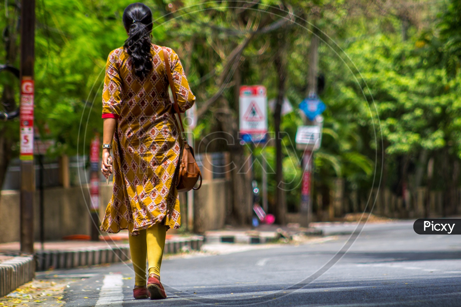 Female/woman walking on the road