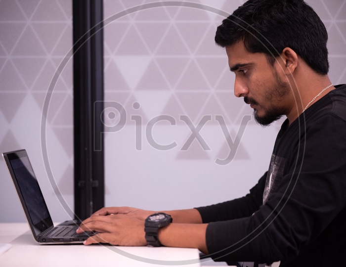 An Indian Working On Laptop in a Office Desk