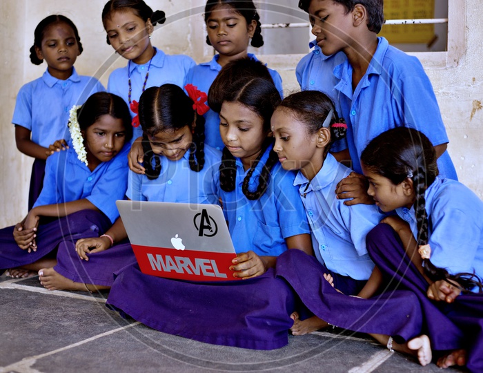 Kids looking at a laptop.