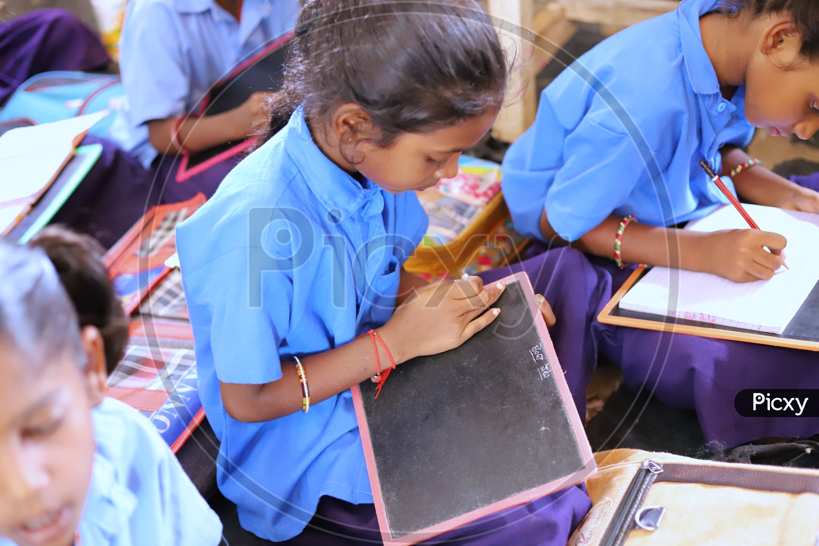 A girl student writing on her slate.