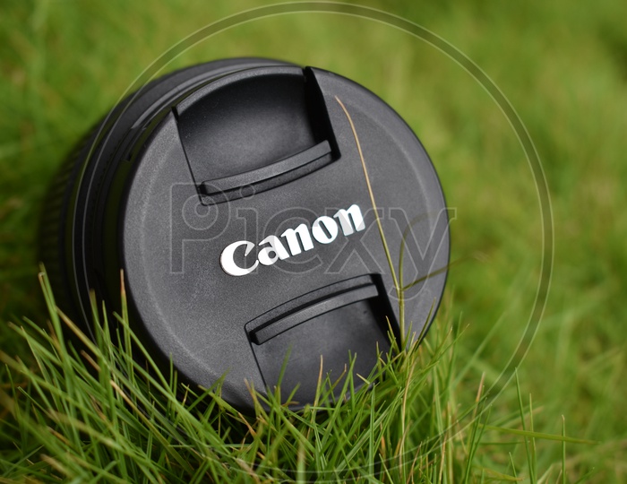 Canon Lens Cap On Green Lawn Grass