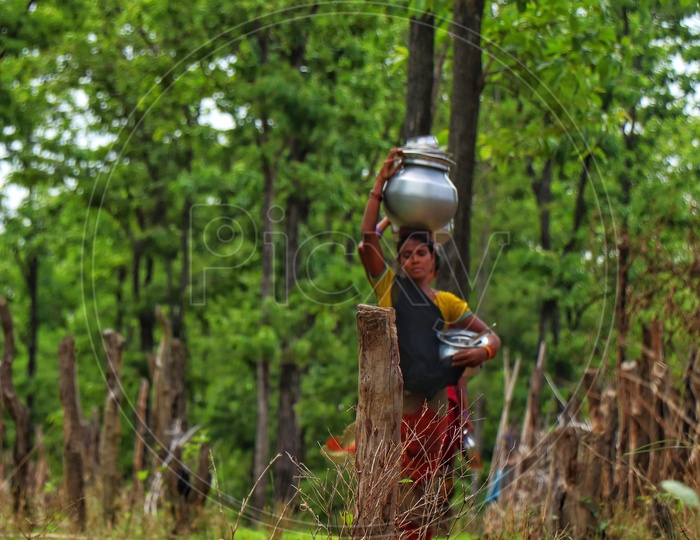 Tribal Woman Carrying Water Vessels on Over Head At a Rural Tribal Village