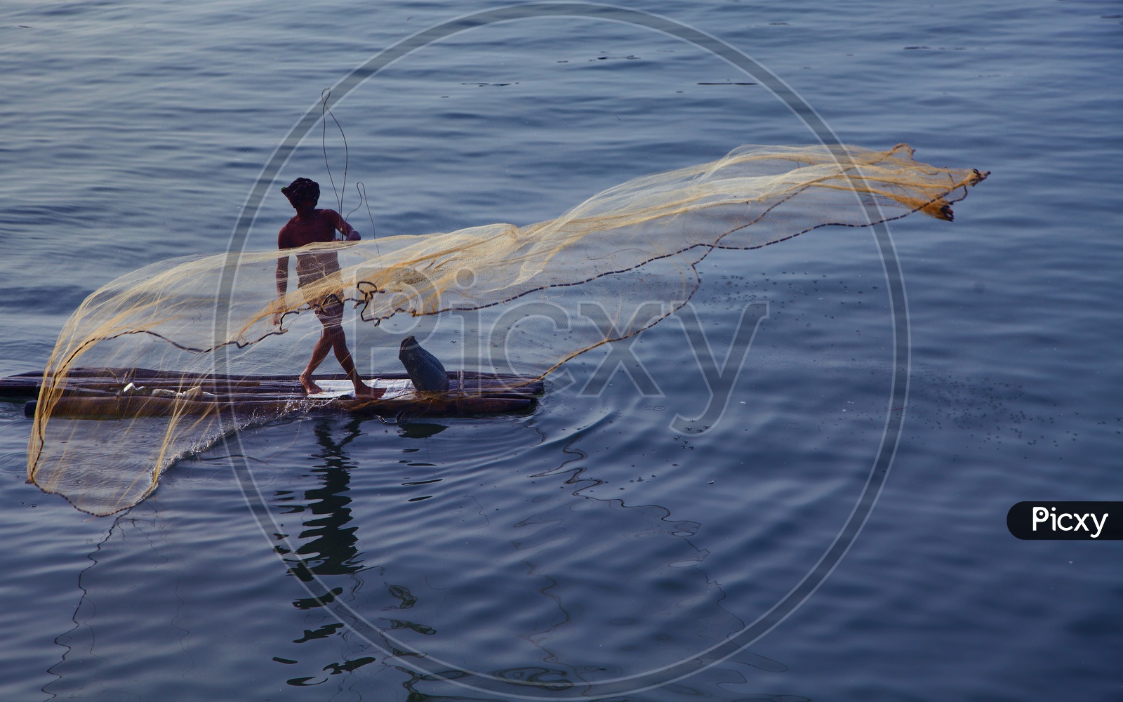 A Fisherman Throwing Fishing Net In a Lake