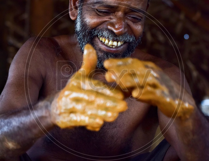 A porter smile while doing his job of making pots.