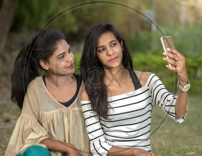 Young Indian Girls students friends  Taking Selfies And Pout in outdoor background