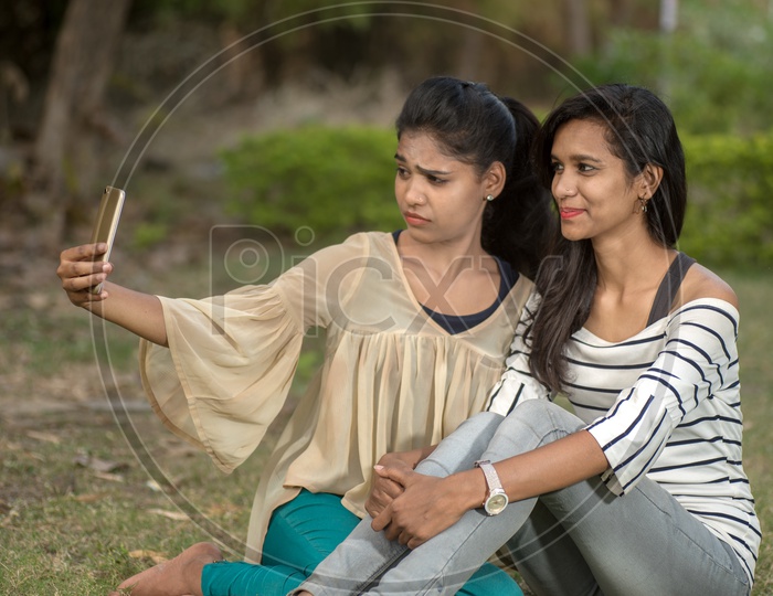Young Indian Girls students friends  Taking Selfies And Pout in outdoor background