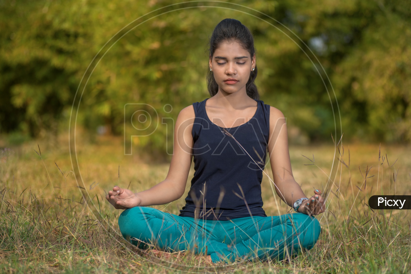Woman Doing Doing Yoga  in Outdoor nature backdrop  meditation exercising  fitness concept relaxing in nature
