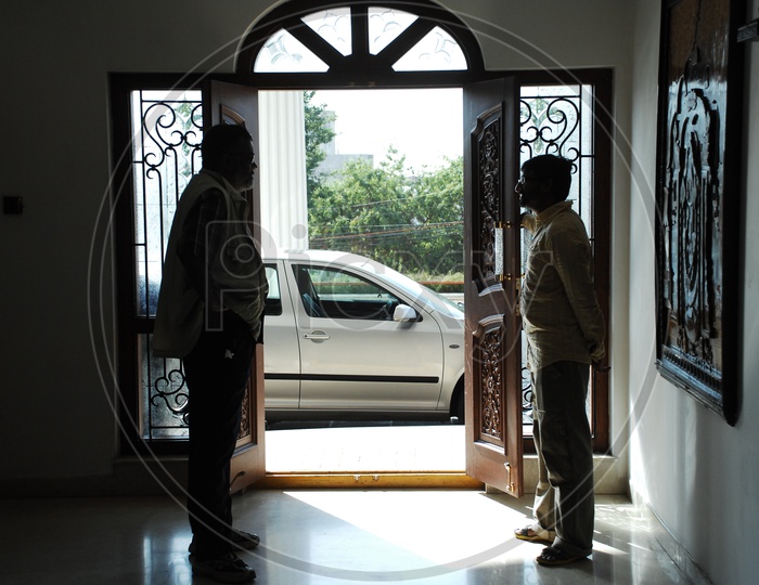 Silhouette Of Men At a House Door