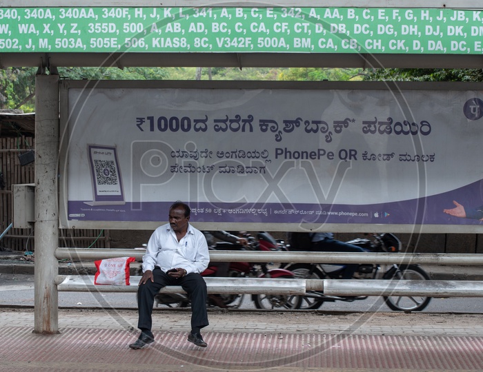 A man waiting for local city Bus at a Bus stop in Bangalore city