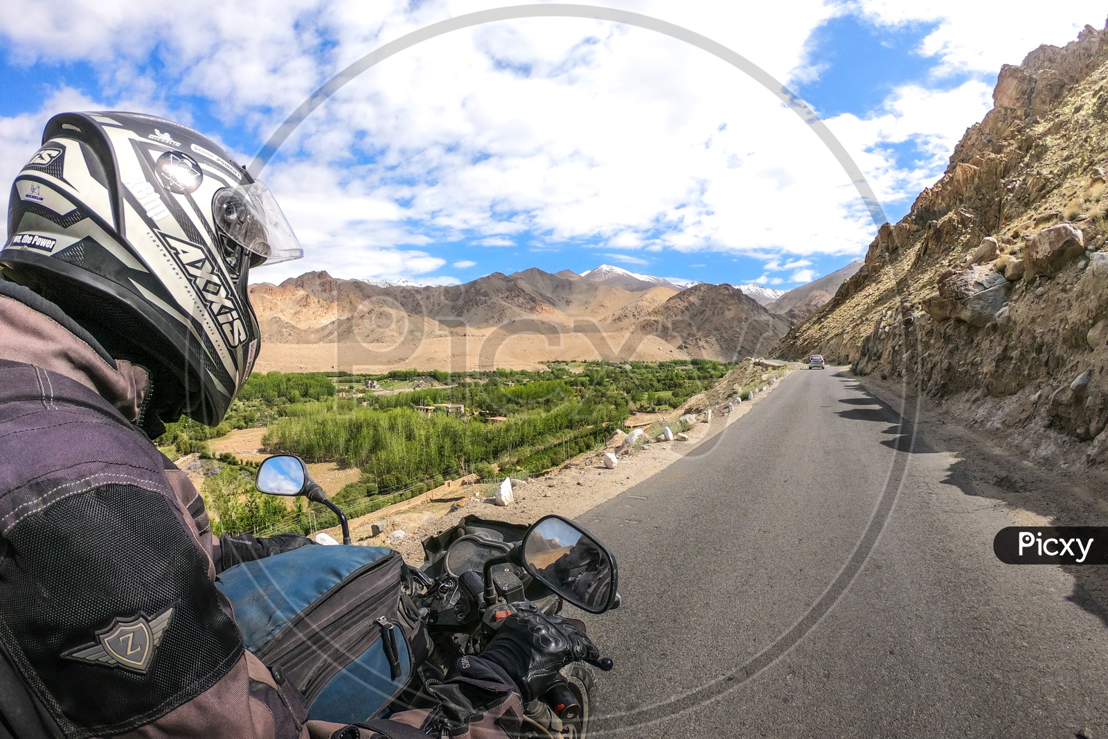 An Adventurer Tourist Biker On the Valley Roads Of Leh With a View Of Snow Capped Mountains