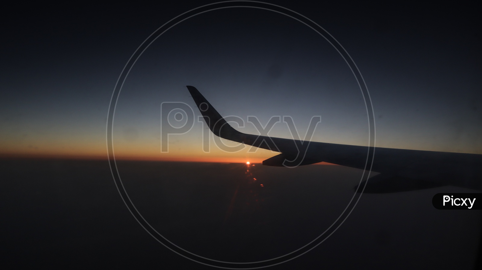 Silhouette Of a Flight Wing Over a bright Sun In Sky