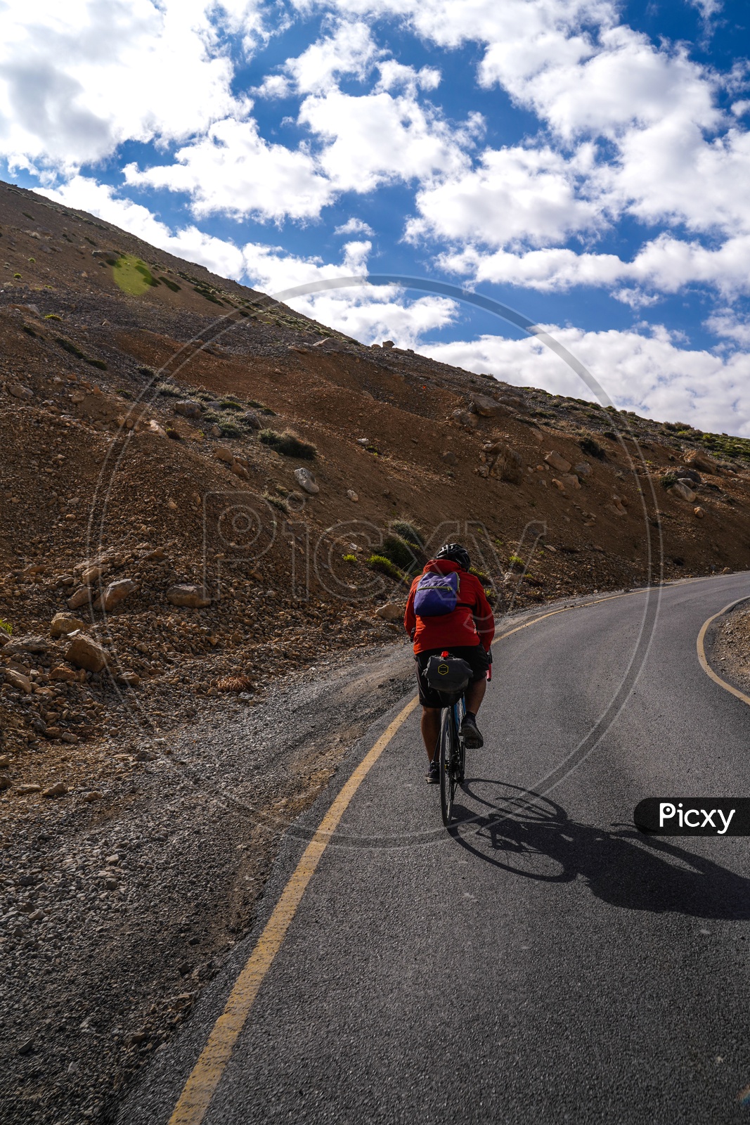 Cyclist  Riding Cycle bike  on The Valley Roads of Leh With a View Of Snow Capped Mountains