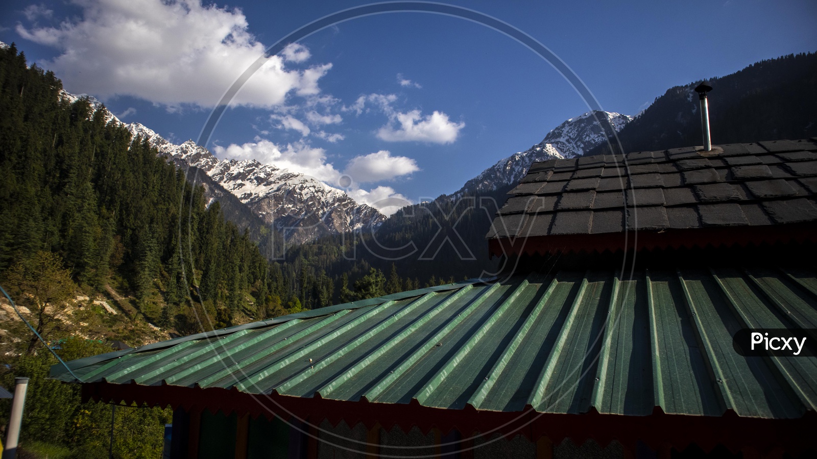 A View Of Snow Capped Mountains From The Roofs Of Village Huts In Leh