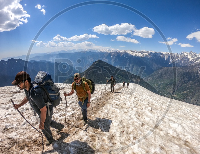 Trekkers Adventurers Climbing Snow Capped Mountains  In Rupin Pass
