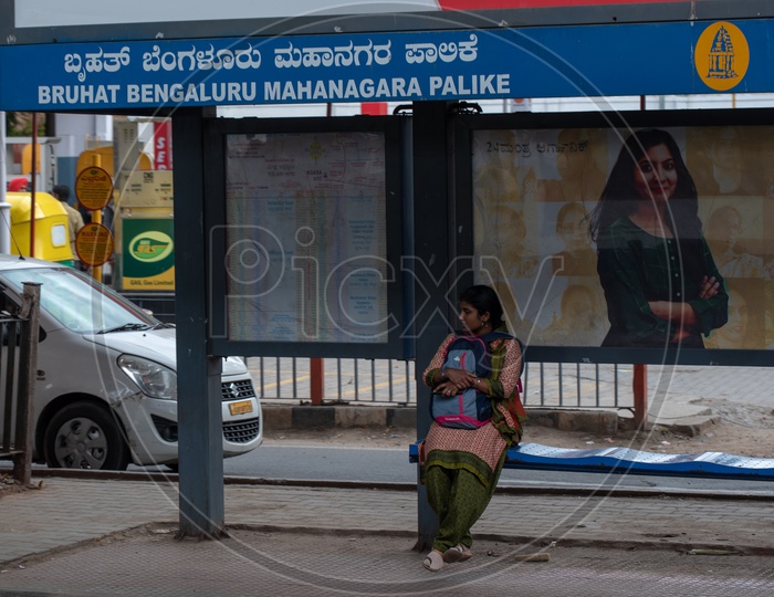 A woman waiting for local city Bus at a Bus stop in Bangalore city