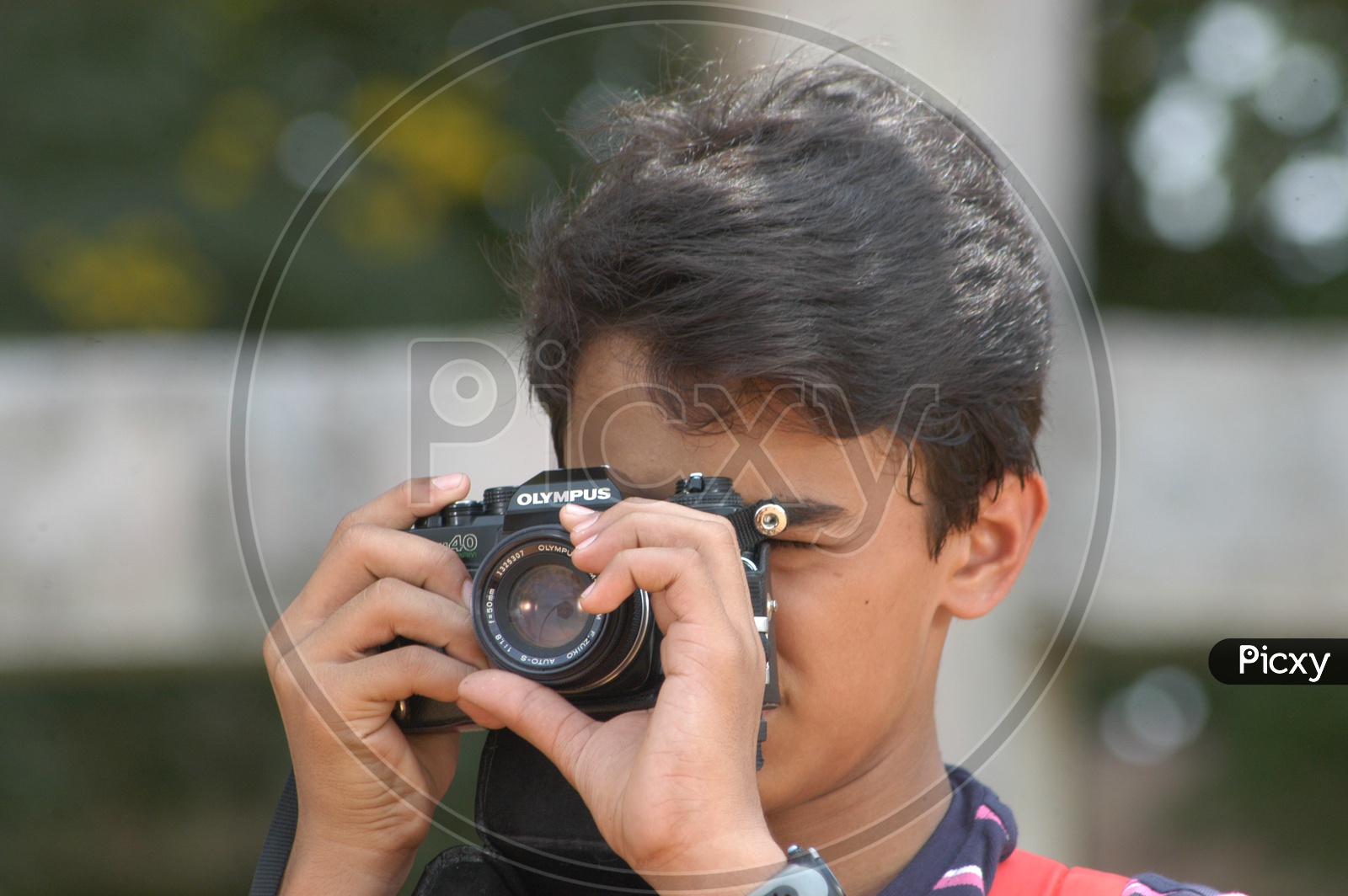 Young Boy clicking photos using Olympus Camera