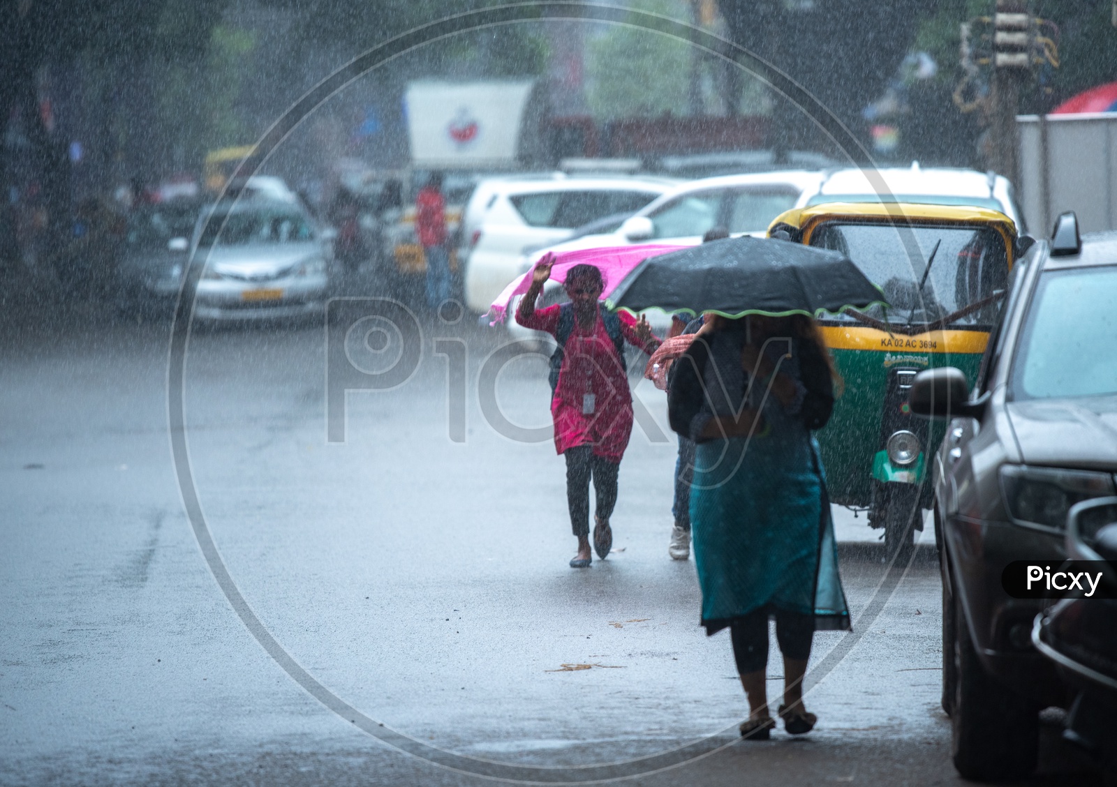 Woman walking with umbrella in heavy Rain