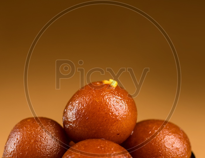 Gulab jamun Indian Sweet or dessert or savourie Served In a black Ceramic Bowl on an Wooden Background