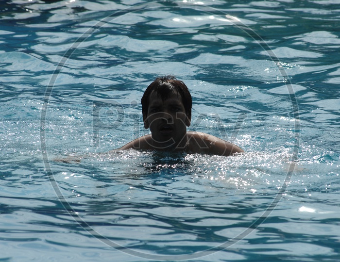 Young Man Swimming in a Pool