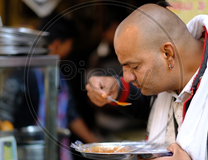 Man Having Breakfast at a Street Food Stall