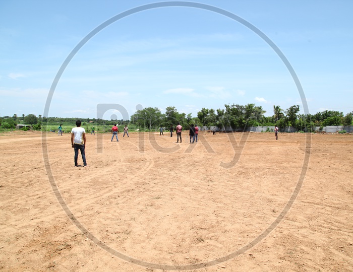 Men Playing Cricket in a Open Ground