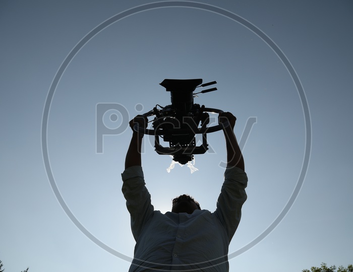 Cinematographer Holding a Sturdy Gimbal Attached To a Movie Shooting Camera