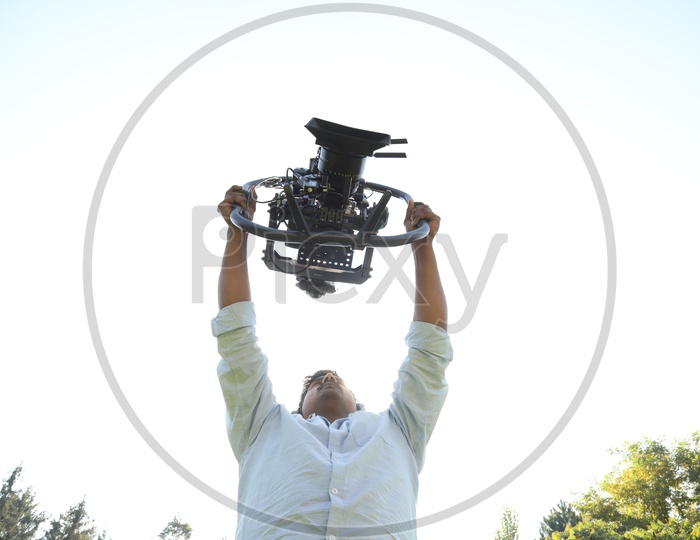 Cinematographer Holding a Sturdy Gimbal Attached To a Movie Shooting Camera