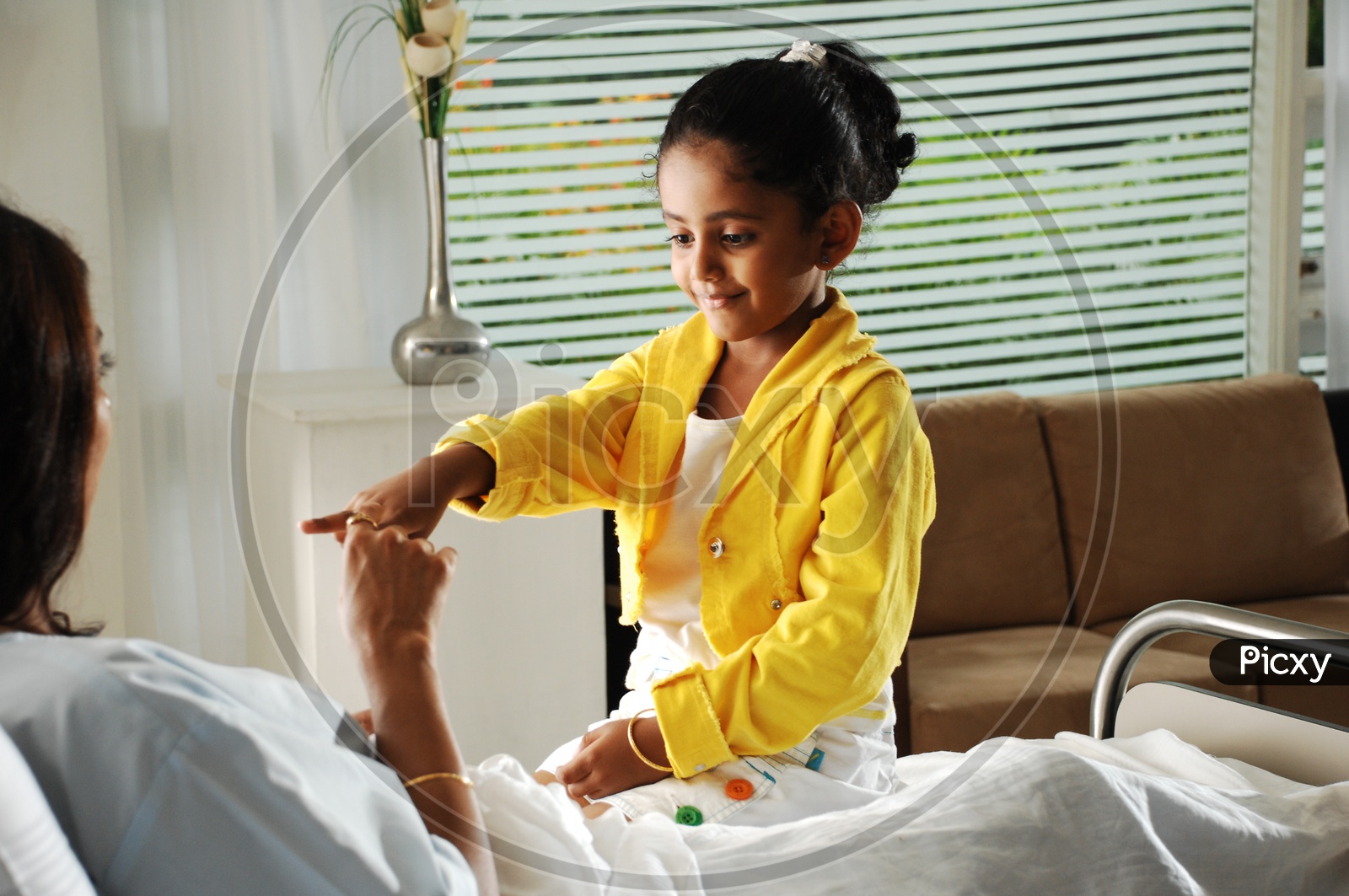 Girl Child Playing With a Woman on Hospital Bed