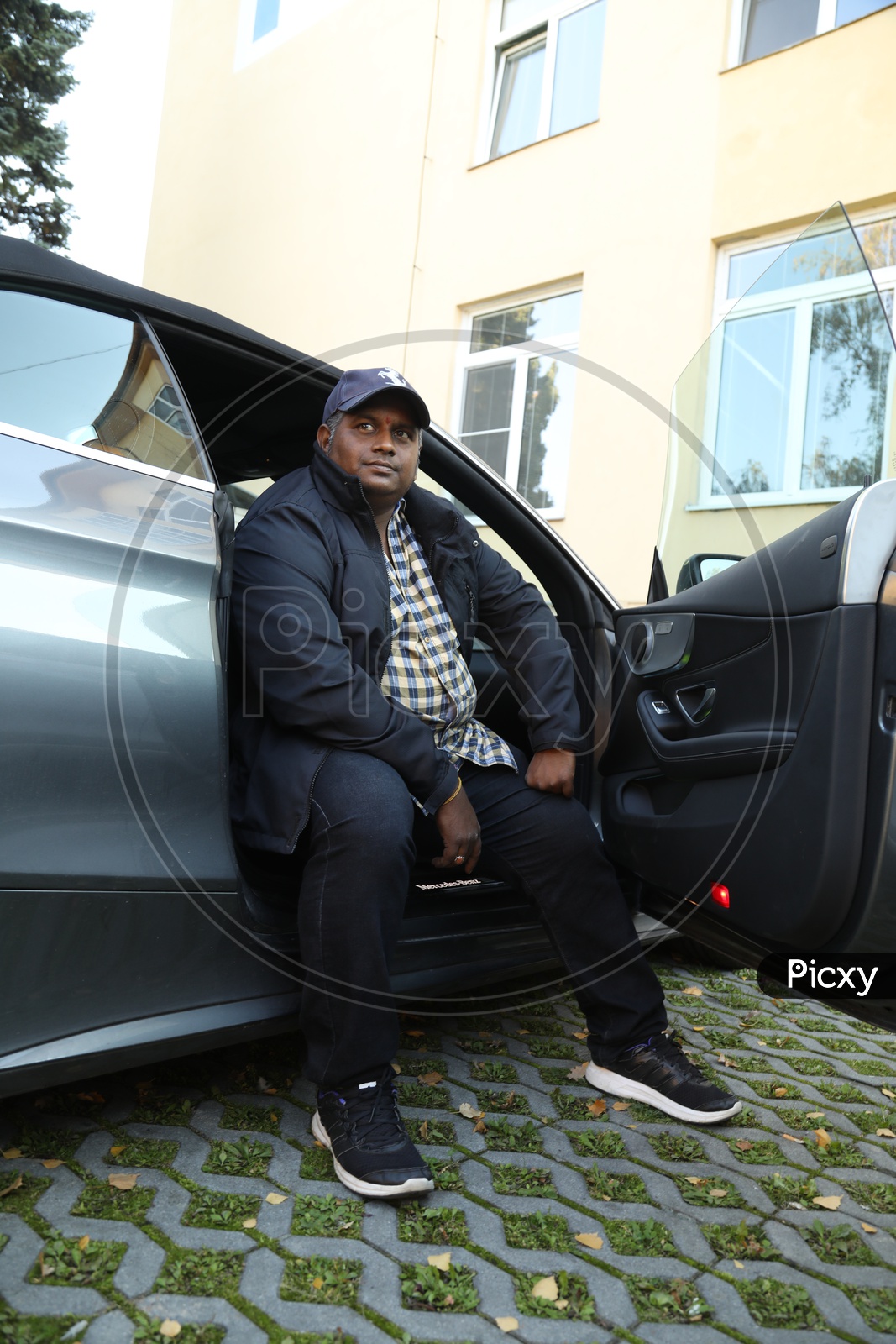 Premium Photo | Man wearing all black posing near suv cars