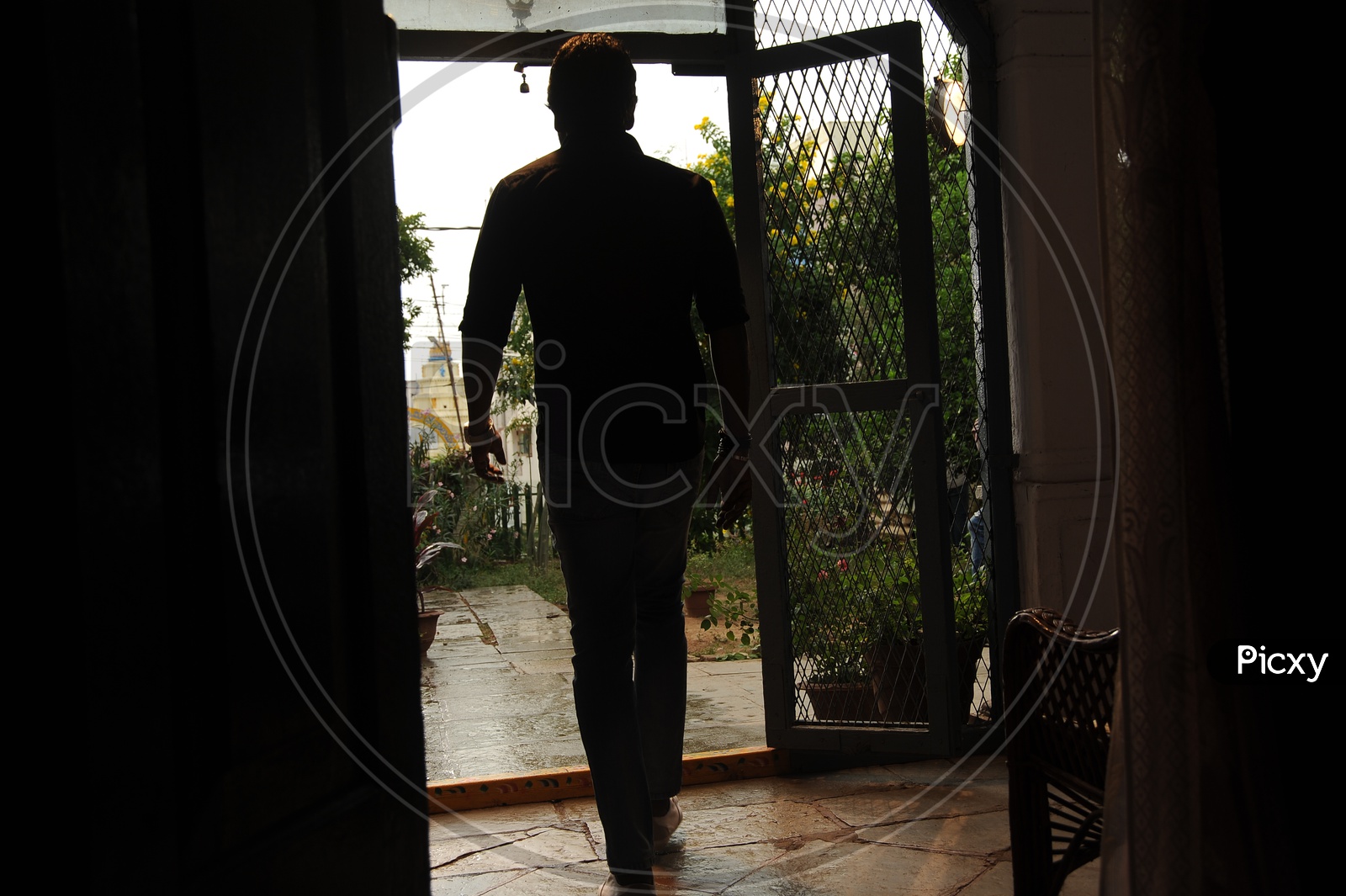 Silhouette Of a Man Walking At a House Entrance