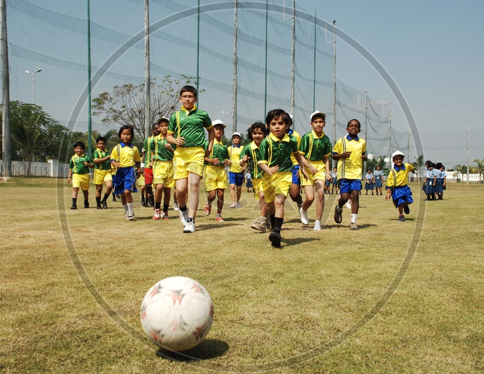 School Children Playing football in a Football Court