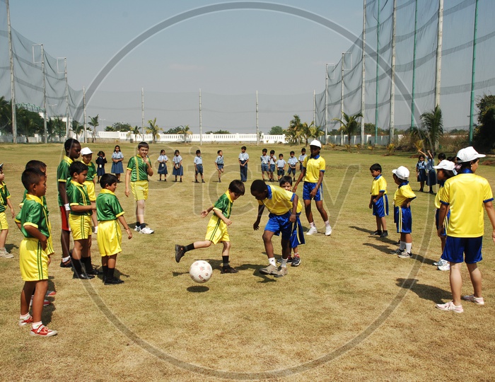 School Children Playing football in a Football Court