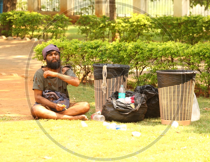 Young Man In Beggar Getup  Sitting in a Park  Lawn   For a Movie Shooting