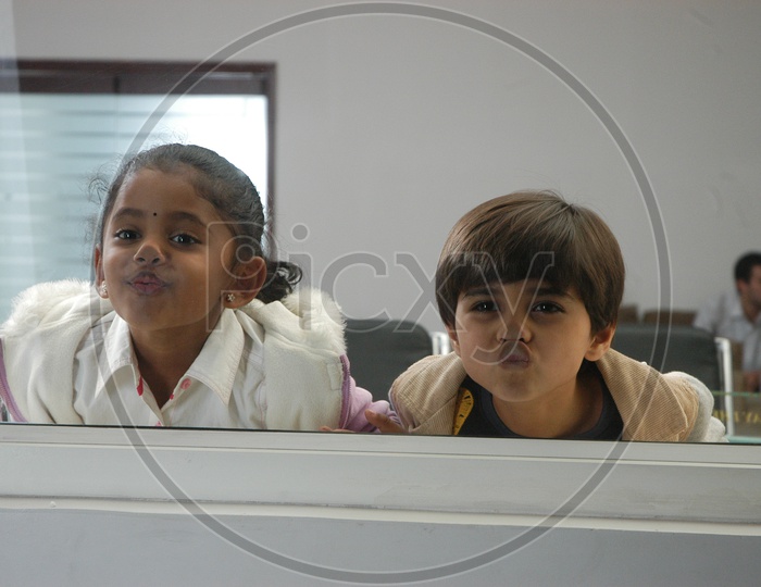 Children Looking Through Glass Window