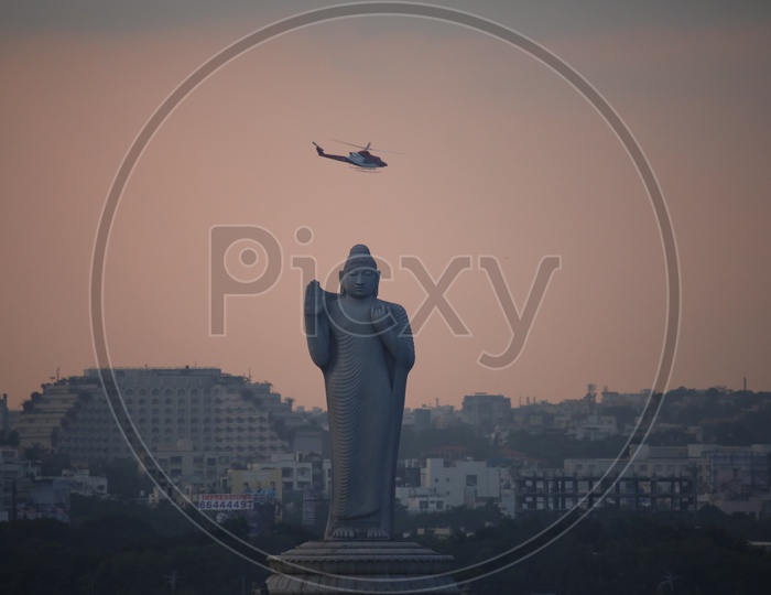 Helicopter Chopper Flying Over Buddha Statue At Tankbund