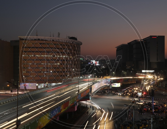 Long exposure   Shot of Fast Moving Vehicles At Hi-tech City Flyover Signal With  Cyber Tower  In Background